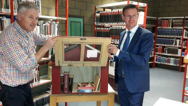 Bibliothecaris Nicolas Cappelle en schepen Kurt Himpe presenteren een boekenkastje. © PVH