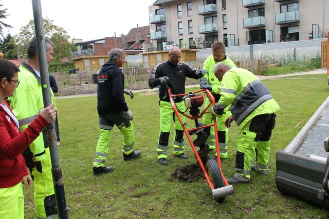 Schepen Grymonprez met een boormachine in de hand, terwijl burgemeester Maertens hem assisteert. - Foto VDI