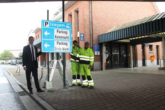 Mobiliteitsschepen Kurt Himpe komt kijken hoe enkele stadsarbeiders de eerste borden van het parkeerroutesysteem plaatsen. - Foto VDI