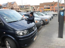 Controleur Franky deelt flyers uit, om bestuurders te wijzen op betalend parkeren. - Foto VDI
