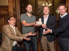 Burgemeester Bert Maertens (tweede van rechts) krijgt het Pretmerletje, waarin de enveloppe met de oplossing zit, in aanwezigheid van schepenen Tom Verbeke (links) en Kurt Himpe (rechts) en Lieven Lamote van de industriële erfgoedsite Eperon d'or. - Foto 
