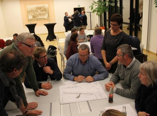 Handelaars en inwoners buigen zich over het voorontwerp tijdens een infomarkt. - VDI Handelaars en inwoners buigen zich over het voorontwerp tijdens een infomarkt. - VDI